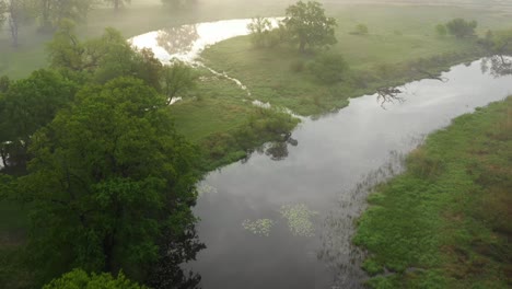 Aerial-shot-of-a-natural-meander-shrouded-in-morning-mist