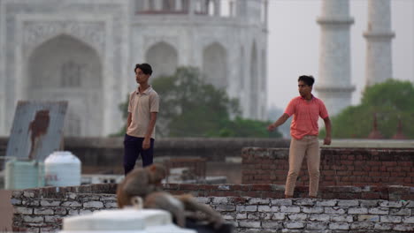 two-Indian-boys-fly-a-kite-with-Taj-Mahal-in-background,-Agra-India