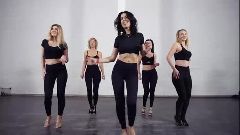 A-group-of-attractive-sportive-women-in-black-active-wear-dancing-bachata-in-ballroom-class