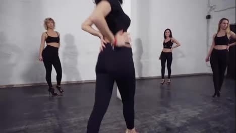 Upward-slow-motion-footage-of-a-group-of-attractive-sexy-women-dancing-bachata,-learning-groovy-moves.