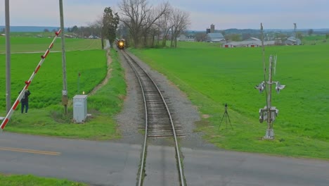 A-Head-on-Drone-View-of-an-Antique-Steam-Passenger-Train-Approaching-While-Traveling-Thru-Farmlands-on-a-April-Day