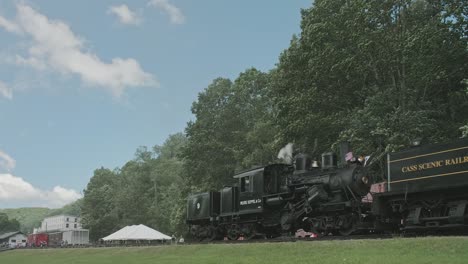 A-Low-View-of-a-Three-Connected-Shay-Steam-Engine,-Backing-Up,-Blowing-Smoke-and-Steam,-Passing-Freight-Cars-on-a-Sunny-Summer-Day
