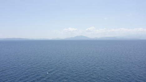Blue-background-aerial-flight-over-calm-Aegean-Sea-on-coast-of-Greece
