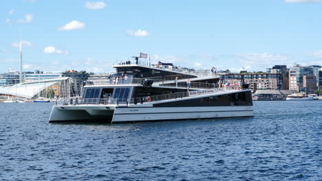 Tracking-shot-of-Oslo-Fjord-Cruise-Ship-on-Sunny-day,-Cityscape-Backdrop