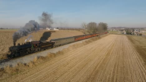 A-Drone-View,-in-Slow-Motion,-of-a-Antique-Steam-Passenger-Train,-Traveling-Thru-Farmlands-on-a-Winters-Day