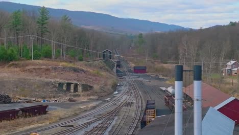 A-Drone-View-of-an-Old-Narrow-Gauge-Rail-Road-Yard-With-Coal-Hoppers-Rusting-on-a-Sunny-Spring-Day