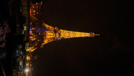 Vertical-video-landscape-view-of-the-Tour-Eiffel-lights-glowing,-from-a-boat-on-the-Seine-river-in-Paris,-at-night,-France
