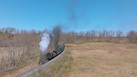 Aerial-View-of-EBT's-Narrow-Gauge-Restored-Antique-Steam-Passenger-Train-Passing-Approaching-Around-a-Curve-With-Steam-and-Smoke-on-a-Clear-Sunny-Day