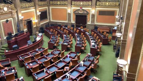Panning-right-to-left-looking-across-all-the-empty-brown-chairs-and-desks-in-the-House-Chamber-of-the-Utah-State-Capital