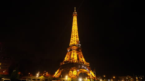 Vista-Panorámica-De-La-Brillante-Gira-Eiffel-Desde-Un-Barco-En-El-Río-Sena-En-París,-Por-La-Noche,-Francia