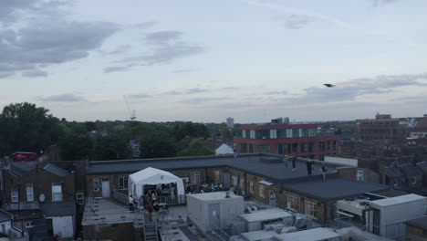 Workers-enjoy-roof-top-afternoon-in-suburban-London-orbiting-aerial