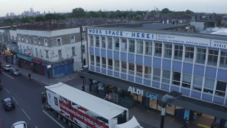 Low-street-aerial-orbits-Work-space-building-on-Holloway-Rd,-London-UK