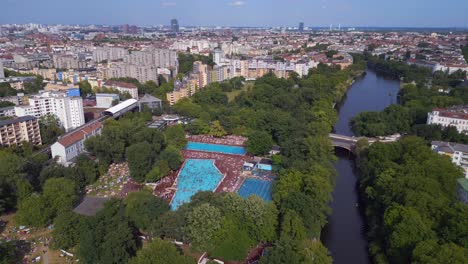 Magic-aerial-top-view-flight-public-swimming-pool-Prinzenbad,-city-Berlin-Germany-Summer-day-2023