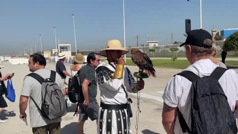 Tourists-curiously-watch-an-eagle-handler-showcase-the-eagle-on-an-excursion-from-MSC-Grandiosa-cruise-ship-in-La-Goulette-Cruise-Port,-Tunisia