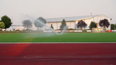 Grass-sprinkler-and-water-sprinkler-in-a-stadium-irrigates-the-green-grass-on-a-sunny-day