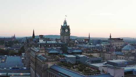 Aerial-shot-of-Edinburgh-at-sunset,-featuring-a-large-clock-tower