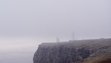 Luftaufnahme-Eines-Nebelbedeckten-Leuchtturms-Auf-Einer-Klippe-An-Einem-Nebligen-Morgen