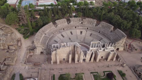Morning-drone-orbit-around-old-roman-ruins-of-Teatro-Romano-in-Merida,-Spain