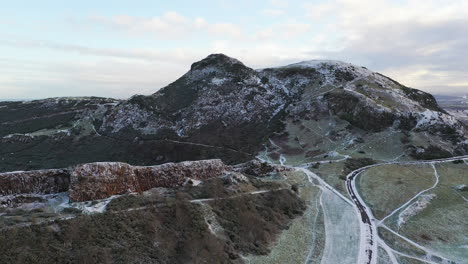 Arial-shot-of-Salisbury-crags-on-Arthurs-seat-in-Edinburgh-on-a-snowy-morning