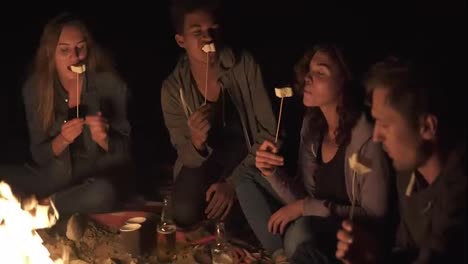 Gruppe-Glücklicher-Multiethnischer-Freunde,-Die-Nachts-Am-Feuer-Campen,-Lachen-Und-Marshmallows-Rösten