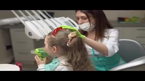 Little-cute-girl-rinsing-her-mouth-with-treatment-at-the-dentist.-Little-child-holding-glass-with-green-fluid-in-her-hand.-Shot-in-4k