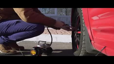 Closeup-portrait-of-a-man-checking-pressure-and-pumping-a-car-tire.
