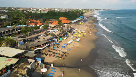 Panoramic-drone-shot-of-overcrowded-Batu-Bolong-Beach,-Canggu,-Indonesia