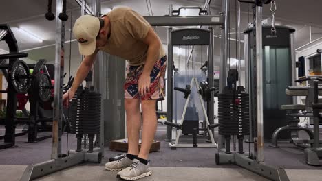 Man-in-shorts-doing-triceps-extension-exercise-in-gym