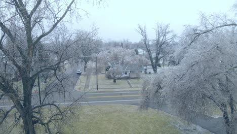Frosty-trees-near-road-in-small-town-of-Warren,-aerial-fly-forward-view