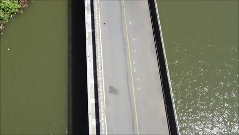 long-cement-bridge-over-reservoir-in-costa-rica,-big-pond,-aerial-video