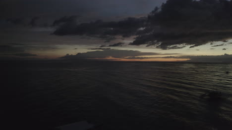 Aerial-footage-of-the-sunset-in-the-Philippines,-Asia-over-water-with-boats,-the-ocean-and-the-sky-in-the-frame,-Drone,-Cinematic