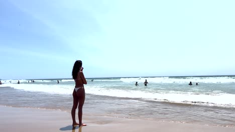 Frau-Mit-Weißem-Bikini-Liegt-Nachdenklich-Am-Strand-Und-Blickt-Auf-Das-Meer-Am-Strand-Von-Caparica