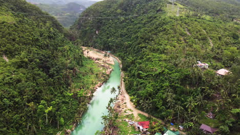 Aufschlussreiche-Wendeaufnahme-Eines-Kleinen-Dorfes-An-Einem-Fluss-In-Einem-Wald-In-Cebu,-Philippinen,-Luftaufnahme,-Drohne,-Filmisch,-Asien