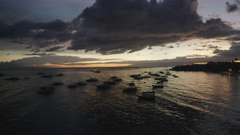 Beweglicher-Sonnenuntergang-Aus-Der-Luft,-Aufgenommen-Auf-Den-Philippinen,-Flug-über-Das-Meer-Mit-Booten-Und-Der-Küste-Im-Rahmen,-Drohne,-Dramatisch,-Sonnenuntergang,-Asien
