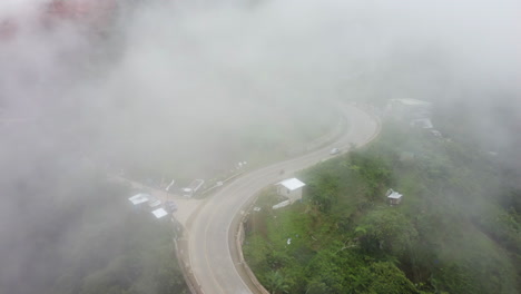 Imágenes-Aéreas-Reveladoras-De-Una-Carretera-En-La-Niebla-Inclinándose-Hacia-Arriba-Revelando-Una-Montaña-Con-Selva-Tropical-En-Filipinas,-Asia,-Drone