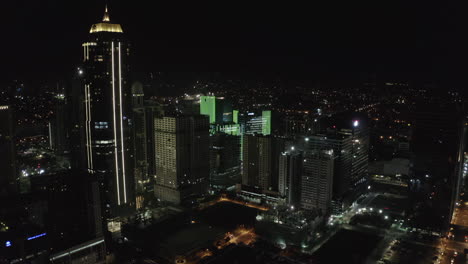 nighttime-Aerial-cityscape-flying-through-downtown-Manila,-Philippines