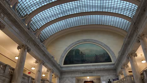 Panning-up-and-across-the-glass-ceiling-of-the-Utah-State-Capital-to-reveal-hand-painted-murals-and-chandelier-then-down-to-see-beautiful-marble-walls,-pillars,-and-stairs