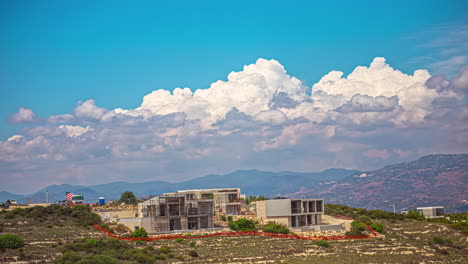 Rolling-billowing-white-clouds-and-blue-sky-above-construction-of-new-modern-luxury-home