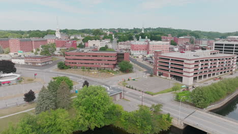 Aerial-View-Unveils-Bangor,-Maine:-Downtown,-Church,-Garage,-and-River-Scene