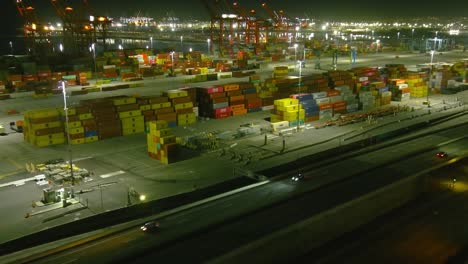 Overhead-flyby-of-Long-beach-shipping-port-|-Night-time-|-Ocean-in-background
