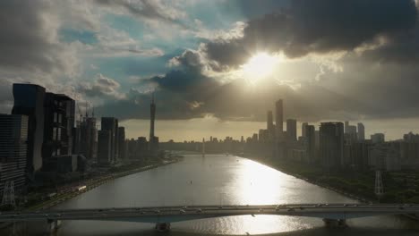 El-Paisaje-Urbano-De-Guangzhou-Con-Rascacielos-A-Lo-Largo-Del-Río-Zhujiang-Y-Los-Icónicos-Puntos-De-Referencia-Del-Centro-En-Segundo-Plano-En-La-épica-Puesta-De-Sol-Nublada-Con-El-Sol-Golpeando-Los-Rayos-De-Dios-Brillando-A-Través-De-Las-Nubes