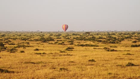 Hot-Air-Balloon-Flight-Ride,-High-View-Flying-Over-Masai-Mara-Landscape-in-Africa,-Aerial-Shot-of-Beautiful-Savannah-Scenery-at-Sunrise-in-Amazing-African-Travel-Experience-Luxury-Ballooning-Trip