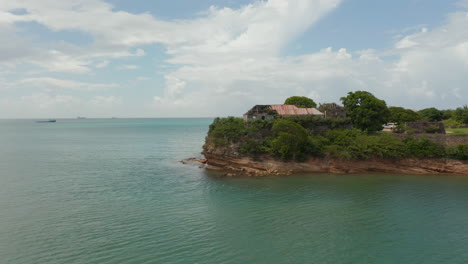 Aerial-establishing-shot-reveal-view-abandoned-building-on-rocky-coastal-bay-in-Antigua-and-Bermuda