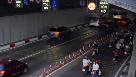 El-Bullicioso-Tráfico-Dentro-Del-Túnel-Del-Río-Saigón-Mientras-Los-Vehículos,-Incluidas-Motocicletas,-Autobuses-Y-Automóviles,-Navegan-Por-Las-Vibrantes-Calles-De-Vietnam