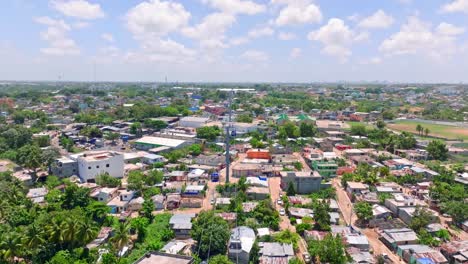 Drone-shot-following-cable-cars-above-slums-of-Santo-Domingo,-in-sunny-Dominican-Republic