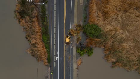 Aerial-view-of-a-tractor-pushing-vegetation-off-the-road