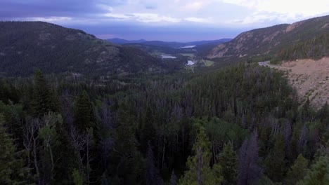 Aerial-Flying-Through-Mountain-Trees-Opening-up-to-Valley-of-Pine-Trees,-Soaring-Over-Beautiful-Colorado-Landscape,-Green-Sea-of-Trees-in-Colorado-Aerial