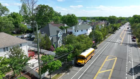 Aerial-view-of-luxury-american-neighborhood-with-villas-and-parking-yellow-school-bus-on-road-during-summer-day