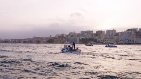 Small-boats-in-the-maritime-procession-of-Villajoyosa-with-colourful-houses-in-the-background