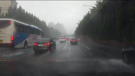 Driver's-POV-Driving-Car-in-Heavy-Rain-on-Gangnam-Expressway-in-Seoul-City,-Heavy-Traffic-Due-to-Rainstorm---View-Through-the-Windshield,-Wiper-Cleans-Raindrops